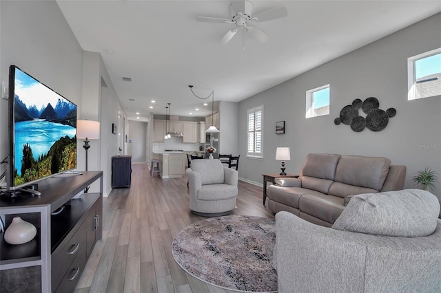 living room featuring hardwood / wood-style flooring, ceiling fan, and a healthy amount of sunlight