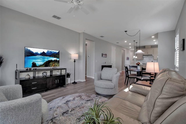 living room with ceiling fan and light hardwood / wood-style flooring