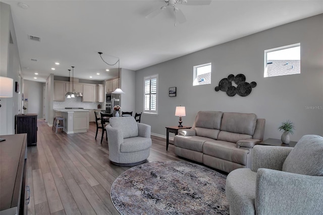 living room featuring ceiling fan and light wood-type flooring