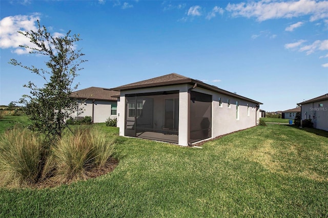 rear view of property with a sunroom and a yard