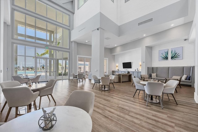 dining area with a high ceiling and light hardwood / wood-style floors