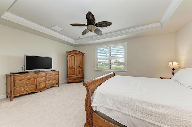 carpeted bedroom with ceiling fan, a tray ceiling, and ornamental molding