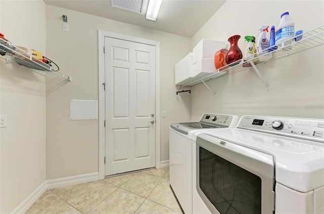 laundry room featuring independent washer and dryer and light tile patterned flooring