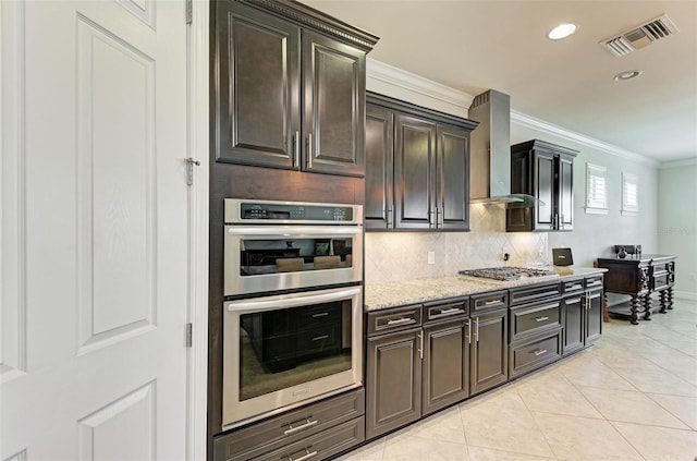 kitchen featuring light tile patterned floors, stainless steel appliances, wall chimney exhaust hood, and dark brown cabinets