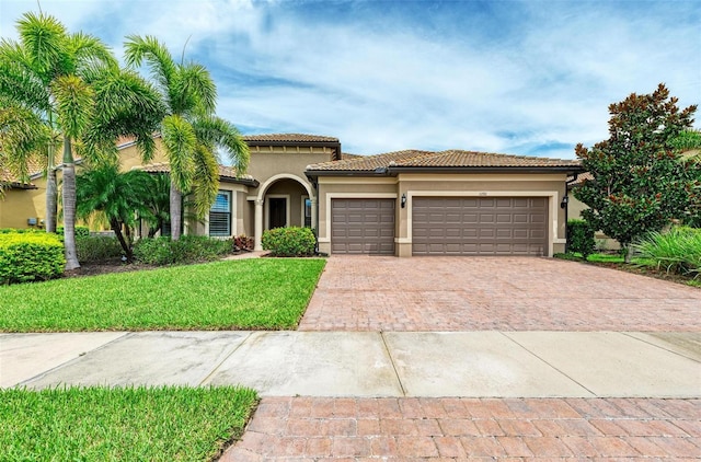 mediterranean / spanish-style home with a front lawn and a garage