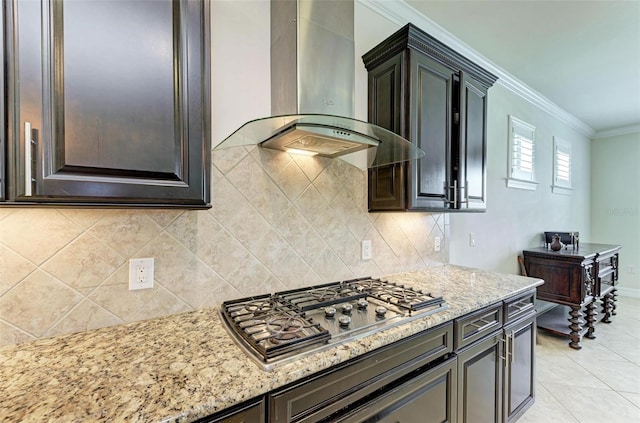 kitchen with light stone countertops, crown molding, stainless steel gas stovetop, and wall chimney exhaust hood