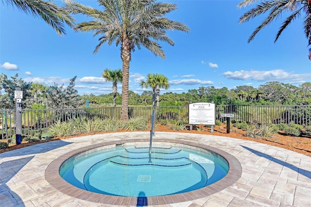 view of swimming pool with a hot tub