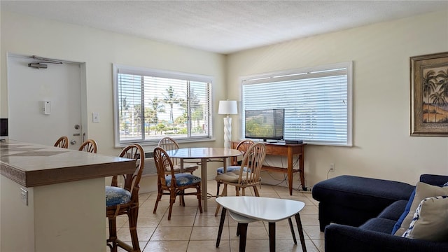 tiled dining area featuring a textured ceiling