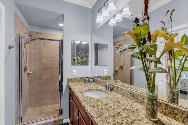 bathroom with a chandelier, vanity, a shower with shower door, and crown molding