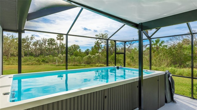 view of swimming pool with a hot tub, glass enclosure, and a lawn