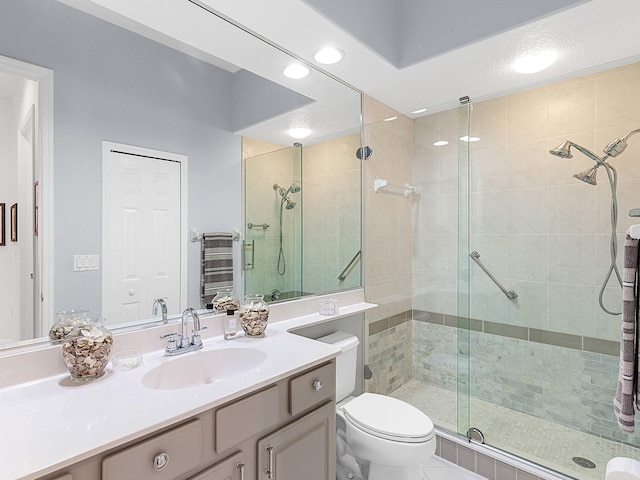 bathroom featuring vanity, toilet, and a shower with shower door