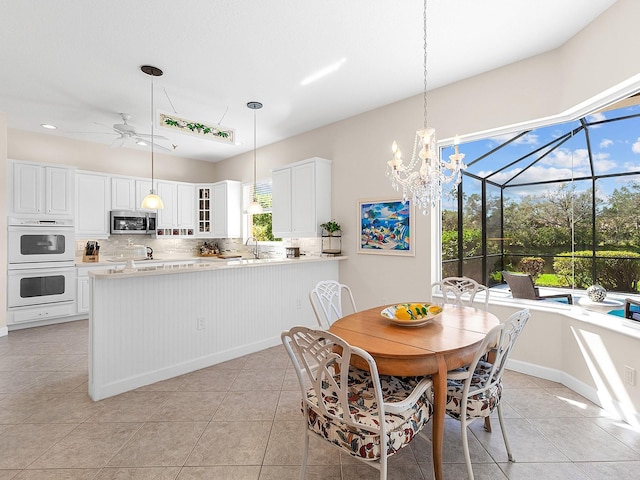 dining room featuring ceiling fan, sink, and light tile patterned flooring