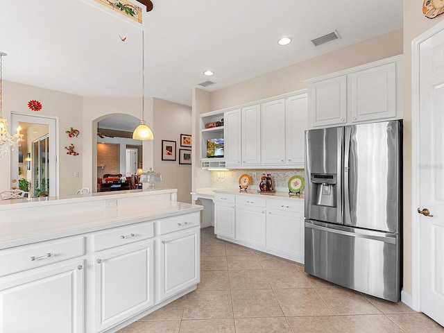 kitchen featuring decorative backsplash, stainless steel fridge, ceiling fan, pendant lighting, and white cabinets