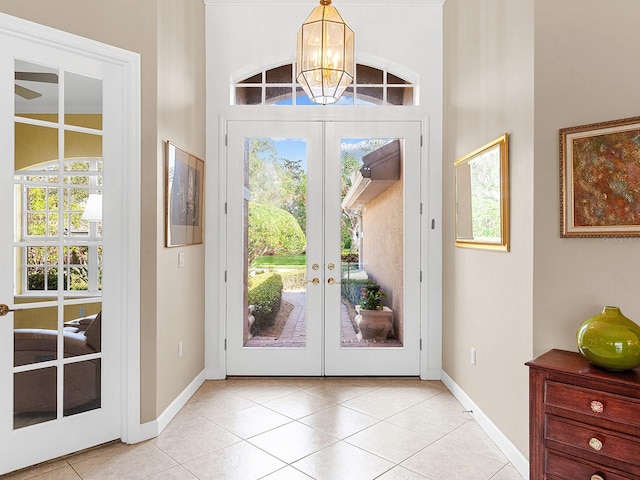 doorway featuring french doors, light tile patterned floors, a wealth of natural light, and a notable chandelier