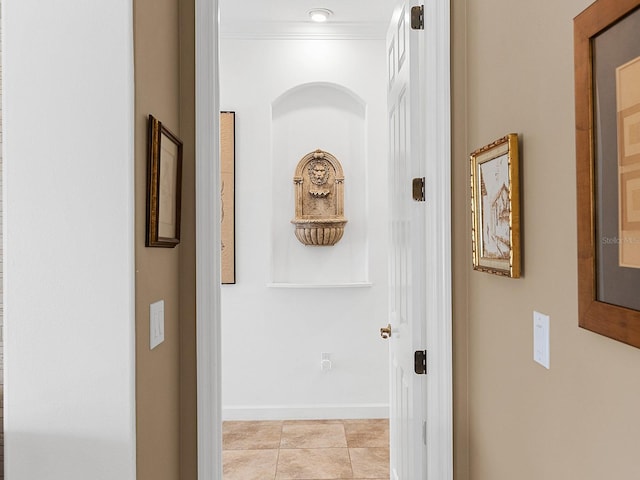 hall with light tile patterned floors and crown molding