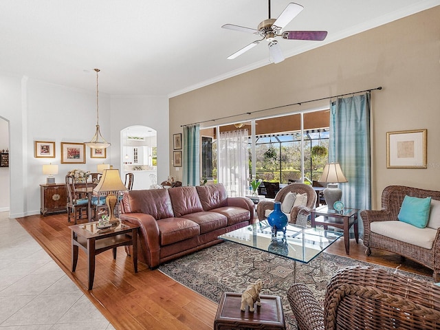 living room with light hardwood / wood-style flooring, ceiling fan, and ornamental molding