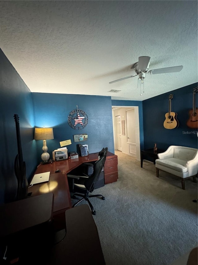 carpeted office space with ceiling fan and a textured ceiling