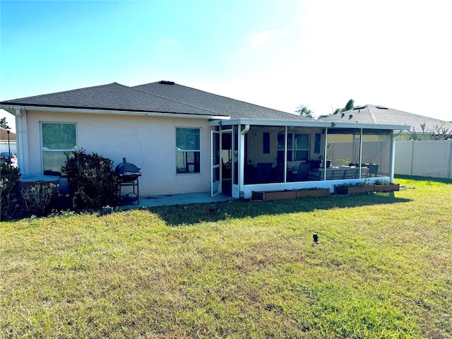 back of property with a sunroom and a lawn