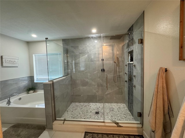 bathroom with tile patterned floors, plus walk in shower, and a textured ceiling