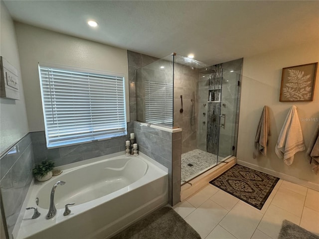 bathroom with shower with separate bathtub and tile patterned floors