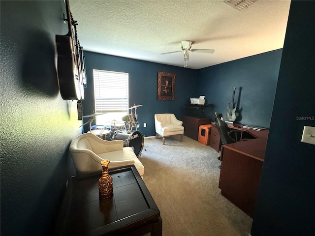 carpeted home office with ceiling fan and a textured ceiling