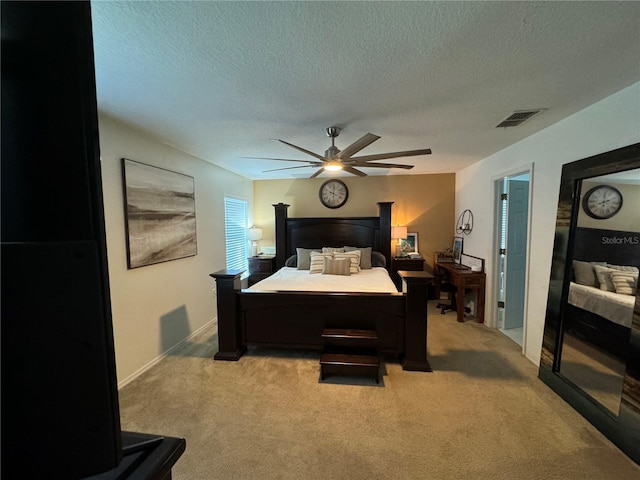 carpeted bedroom featuring ceiling fan and a textured ceiling