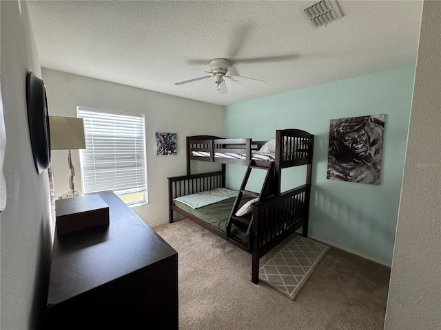 carpeted bedroom featuring a textured ceiling, stainless steel refrigerator, and ceiling fan