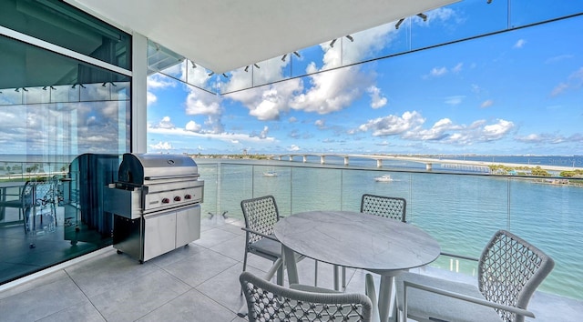 view of patio featuring grilling area, a balcony, and a water view