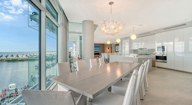 dining area with a water view and a chandelier