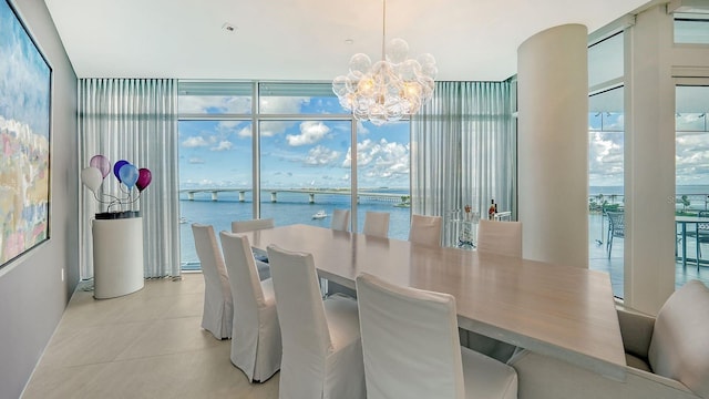 dining space featuring expansive windows, a water view, and an inviting chandelier