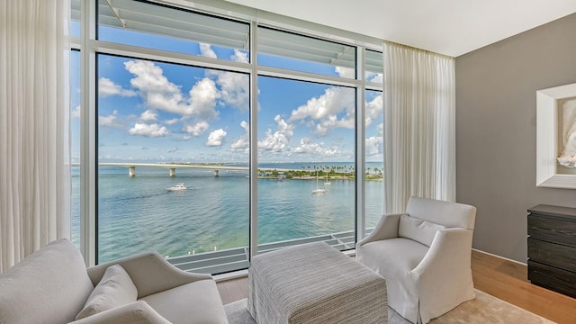 interior space with a water view, floor to ceiling windows, and light hardwood / wood-style floors