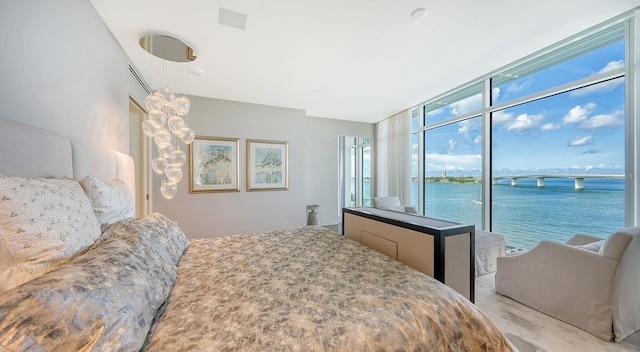 carpeted bedroom with a water view and access to outside