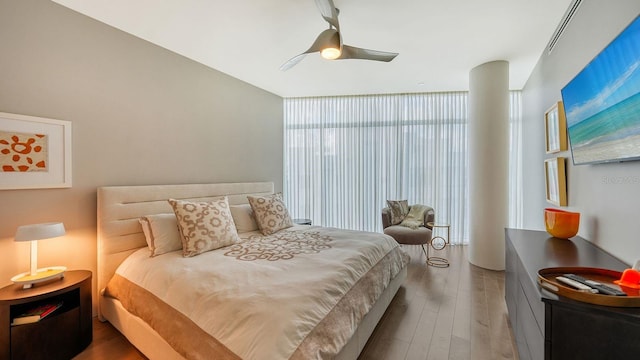 bedroom with floor to ceiling windows, wood-type flooring, and ceiling fan