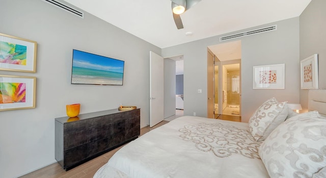 bedroom featuring ceiling fan, light wood-type flooring, and ensuite bath