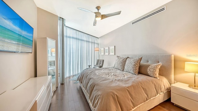 bedroom with hardwood / wood-style flooring, ceiling fan, floor to ceiling windows, and vaulted ceiling