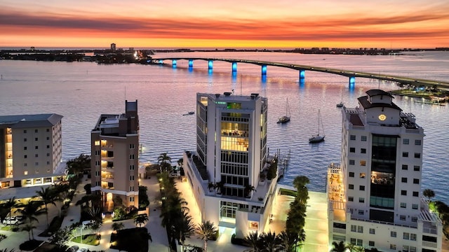 aerial view at dusk featuring a water view