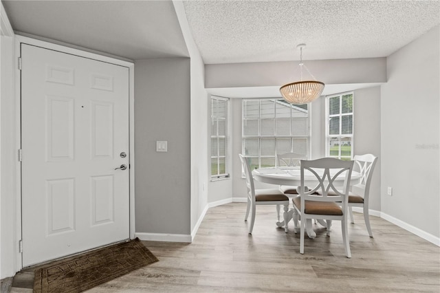 dining room featuring light hardwood / wood-style floors and a textured ceiling