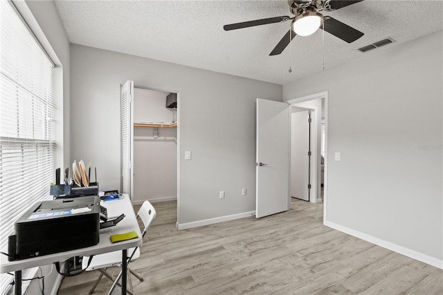 office area featuring ceiling fan, light wood-type flooring, and a textured ceiling