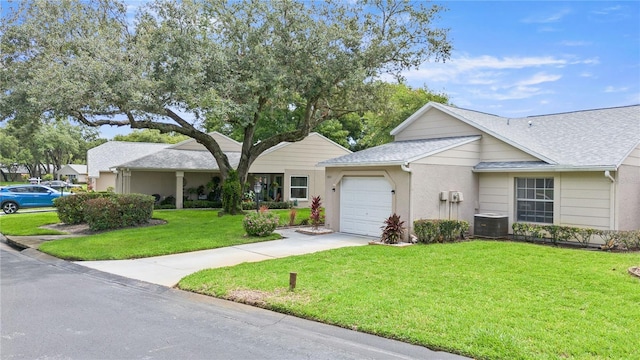 ranch-style house featuring a garage, a front lawn, and central air condition unit