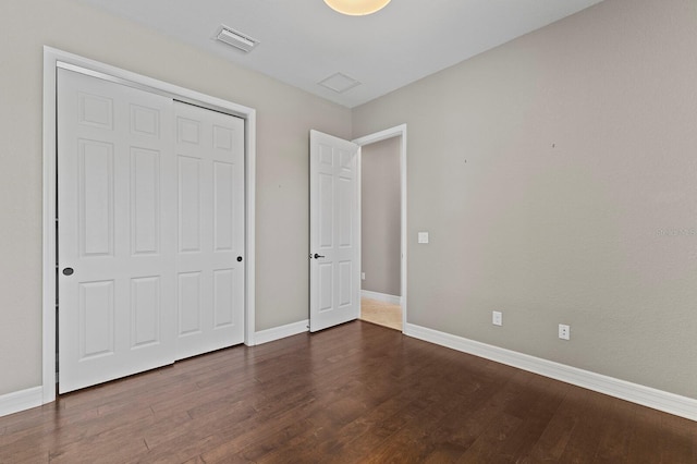 unfurnished bedroom featuring dark hardwood / wood-style flooring and a closet