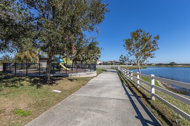 view of home's community with a playground and a water view