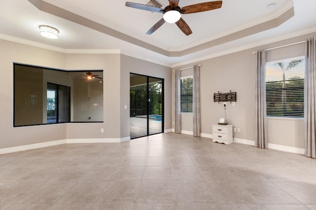 tiled empty room featuring ceiling fan, a raised ceiling, and ornamental molding