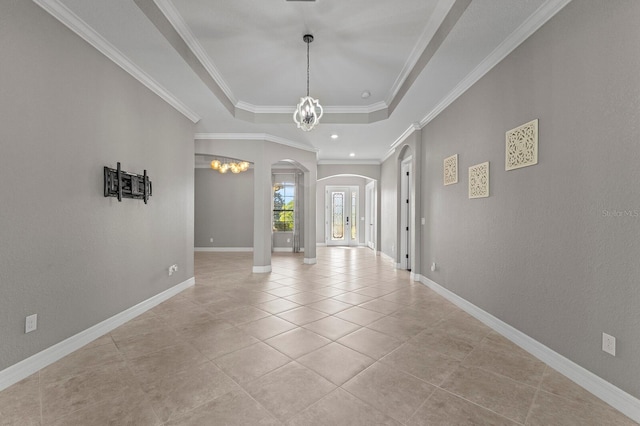 entryway with light tile patterned floors, crown molding, a tray ceiling, and an inviting chandelier