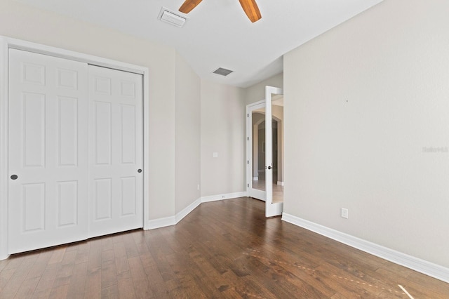 unfurnished bedroom with a closet, ceiling fan, and dark hardwood / wood-style flooring