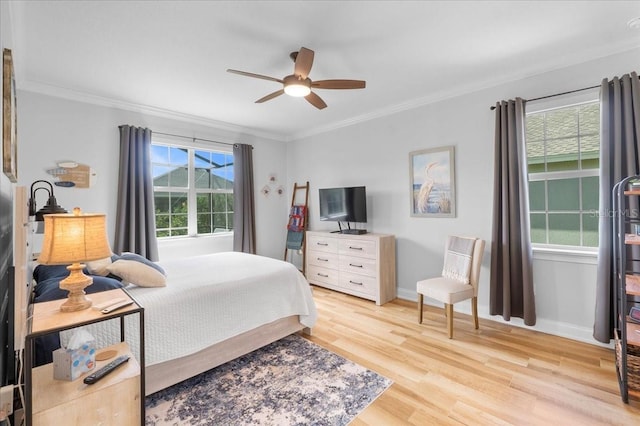 bedroom featuring ceiling fan, light hardwood / wood-style flooring, and crown molding