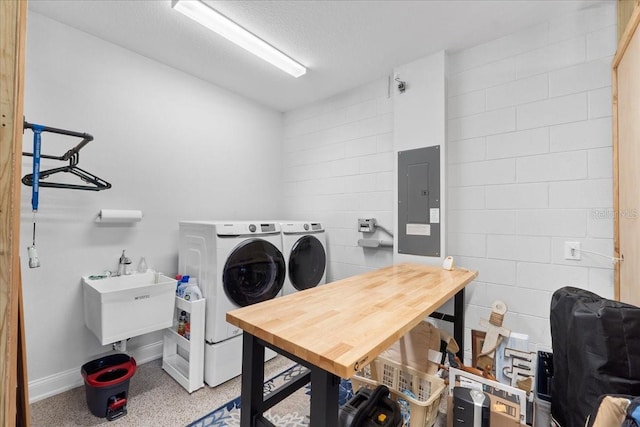 laundry area featuring washer and clothes dryer, sink, electric panel, and a textured ceiling