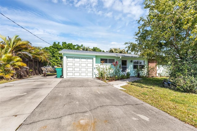 ranch-style home featuring a garage and a front lawn