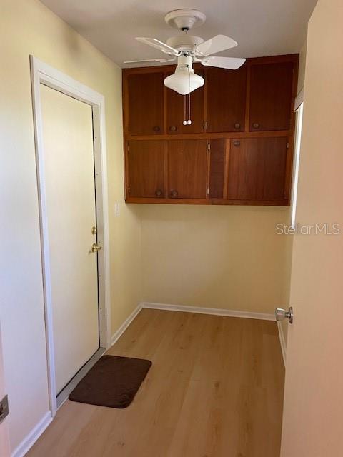 laundry room featuring ceiling fan and light wood-type flooring