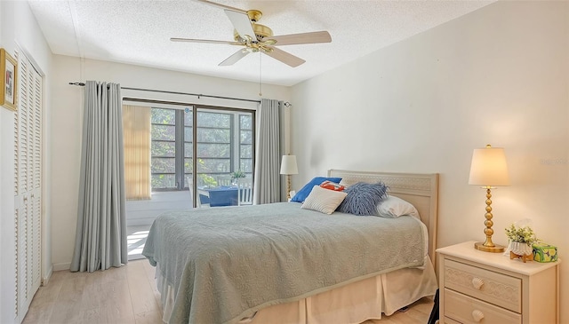 bedroom featuring access to exterior, a textured ceiling, light hardwood / wood-style flooring, and ceiling fan