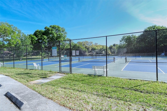 view of tennis court featuring a yard